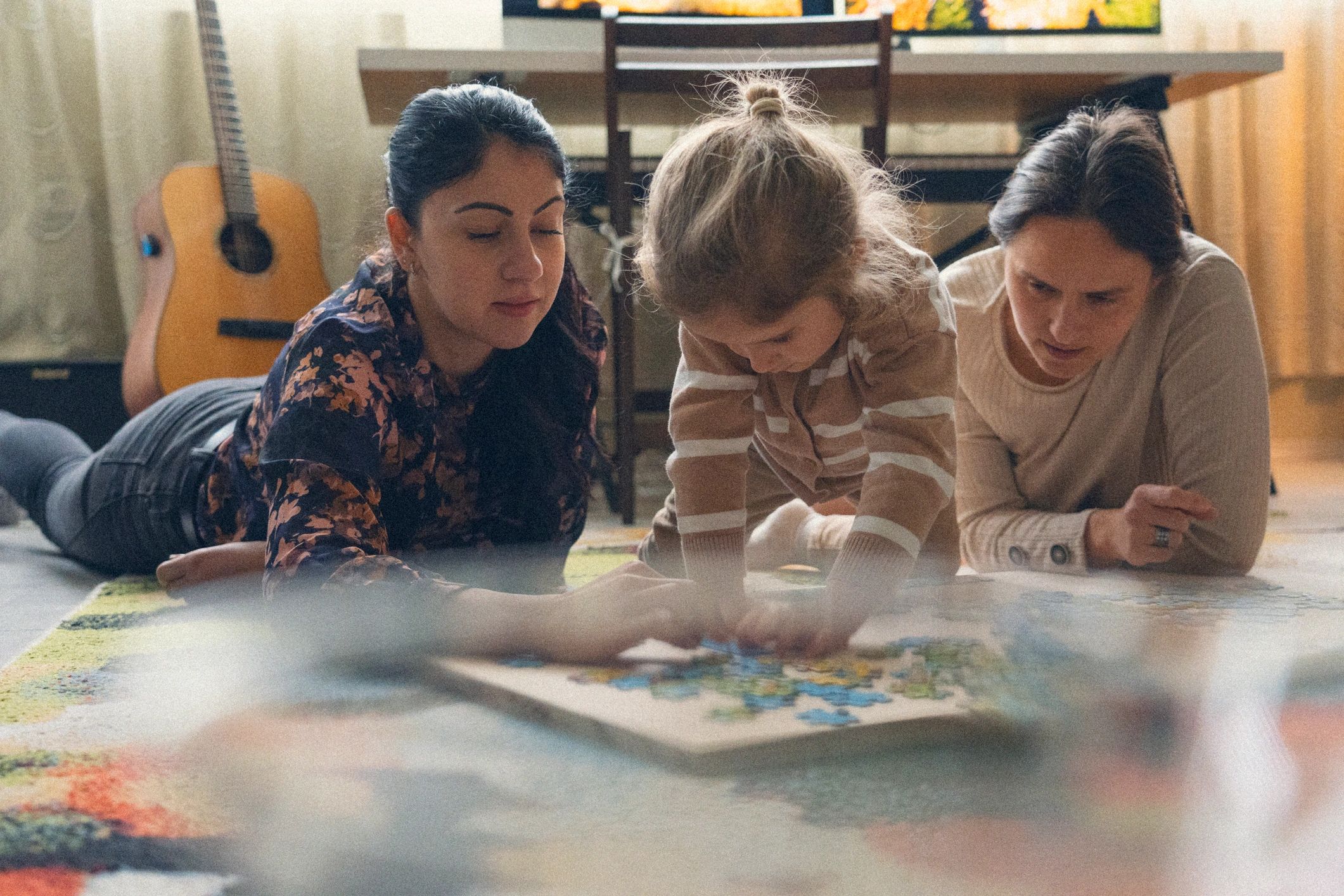 Familia y niñez aprendiendo juntas mediante una actividad con rompecabezas