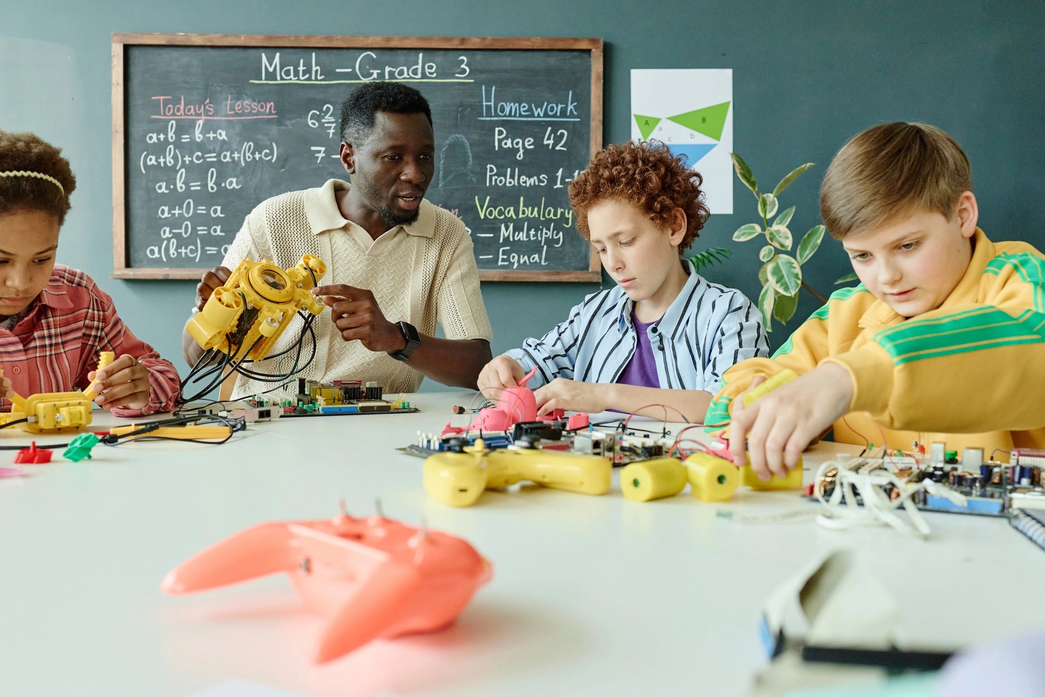 Docente acompañando a niños que construyen robots en un laboratorio STEAM